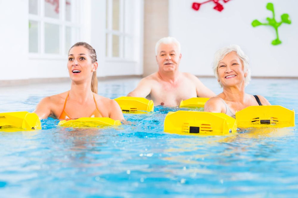 Three adults in the pool for an aquafit class.