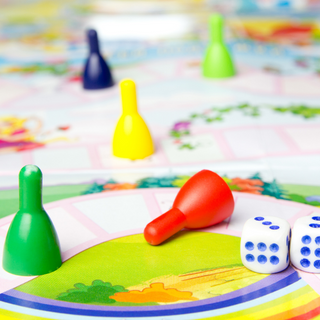 Pawns of various colours and dice strewn across a board game.
