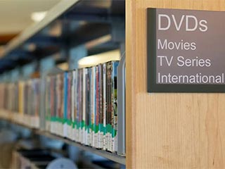 A row of DVDs on the library shelves