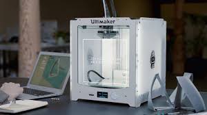 Ultimaker 2+ 3D printer machine sitting on a desk with a laptop