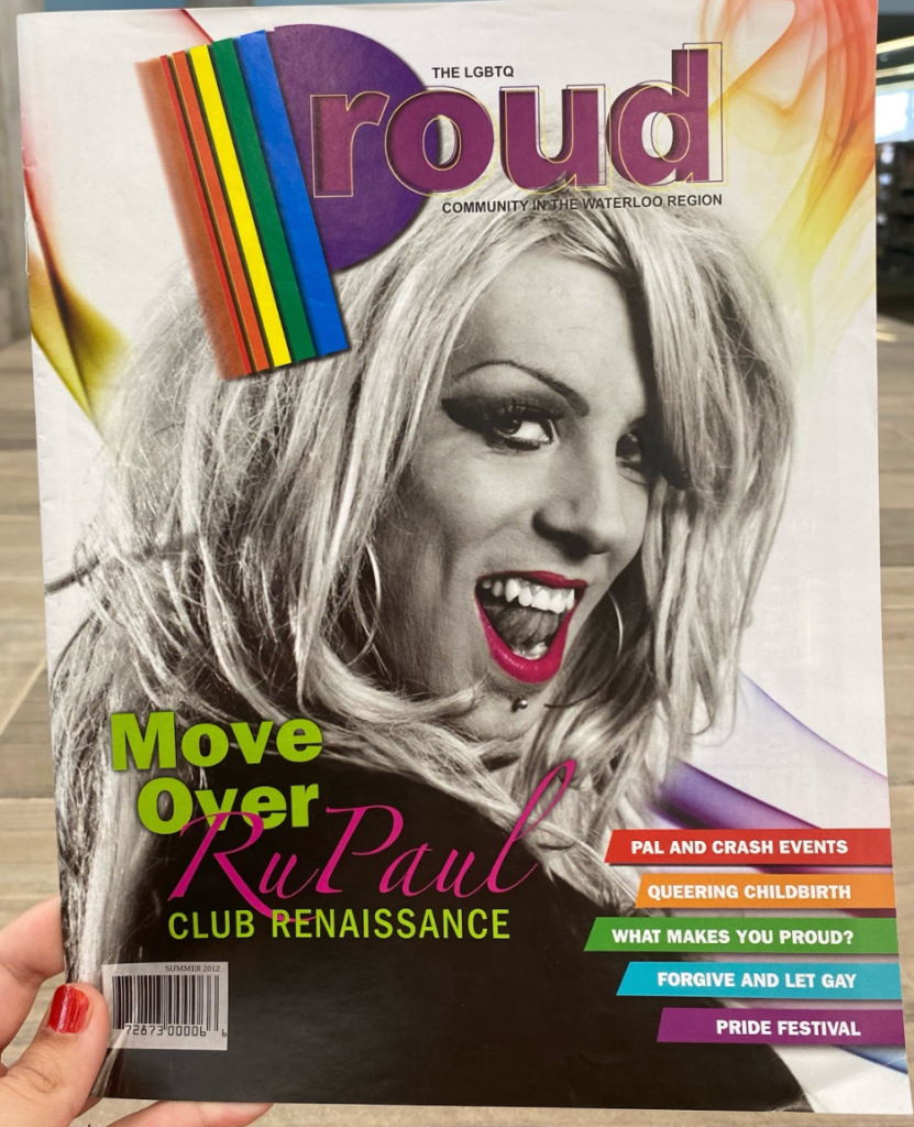 A photo of the cover of Proud magazine. This LGBTQ+ magazine was published by the KW Record. This was the first issue, from 2010, and featured drag performer Sheena Therrien on the cover.